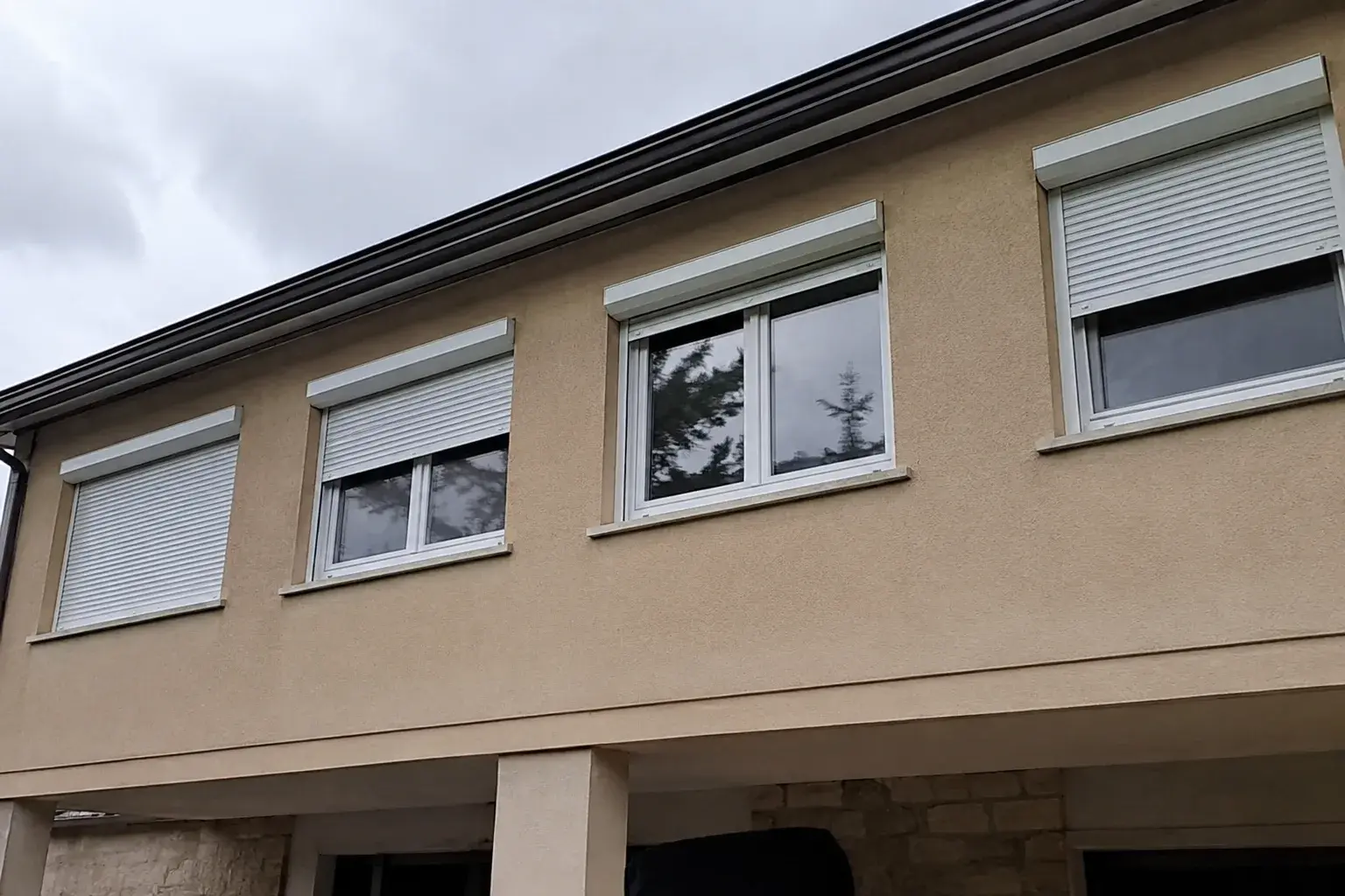 Kuća sa belim roletnama na prozorima sprata