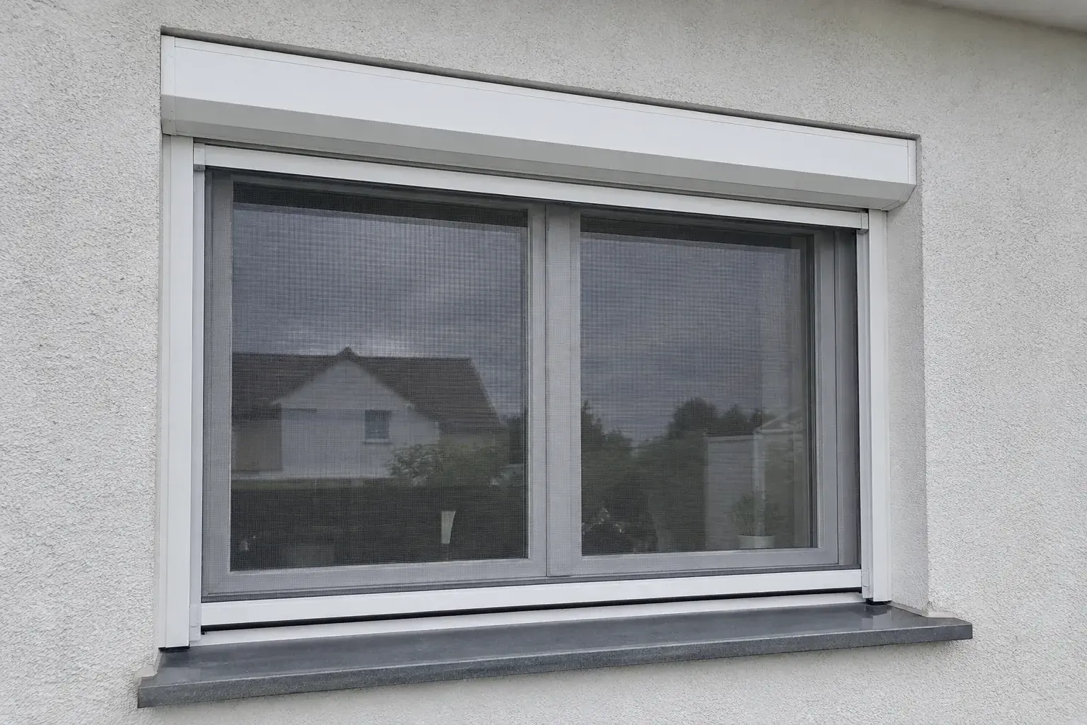 PVC prozor sa podignutom roletnom i spuštenim komarnikom iz iste kutije