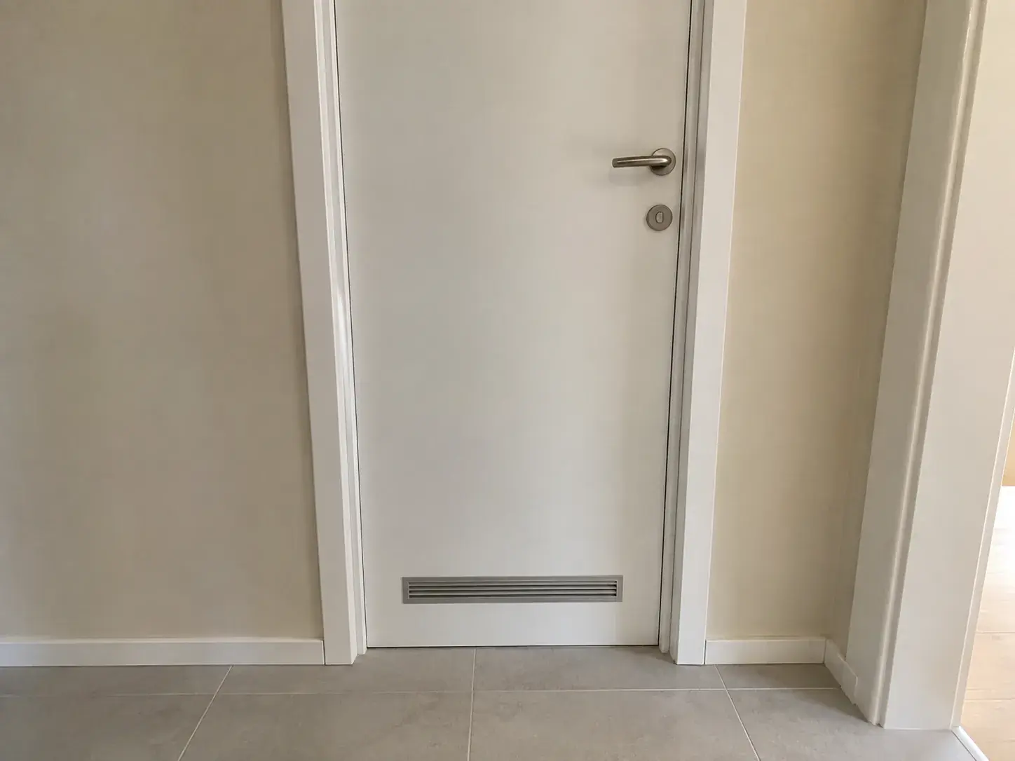 Bela puna sobna vrata sa ventilacionom rešetkom pri dnu krila